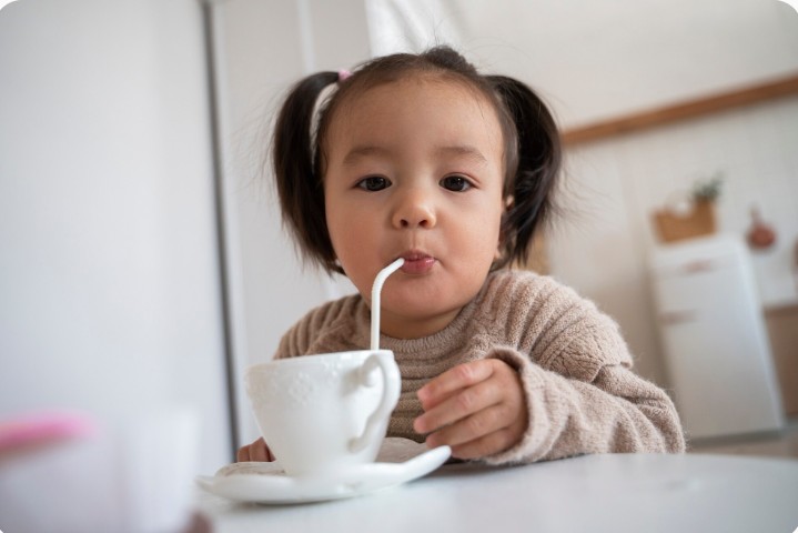 Kanak-kanak sedang minum susu suam di rumah semasa mengalami selsema dan kurang selesa